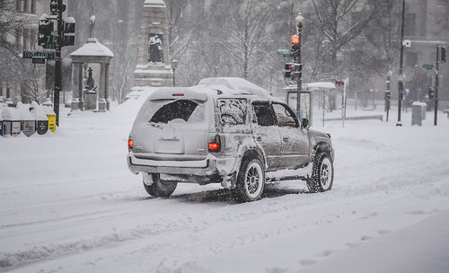 Snow-Covered SUV Driving on Icy Cold City Street