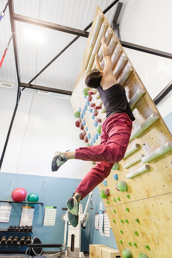 Man at Roca Climbing Gym in Rochester, MN Using Hangboard