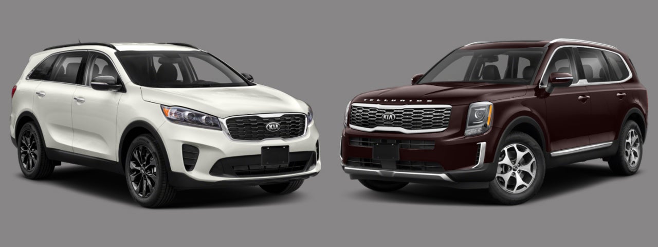 2020 Kia Sorento SUV in Snow White Pearl and 2020 Kia Telluride SUV in Sangria Red against Gray Background