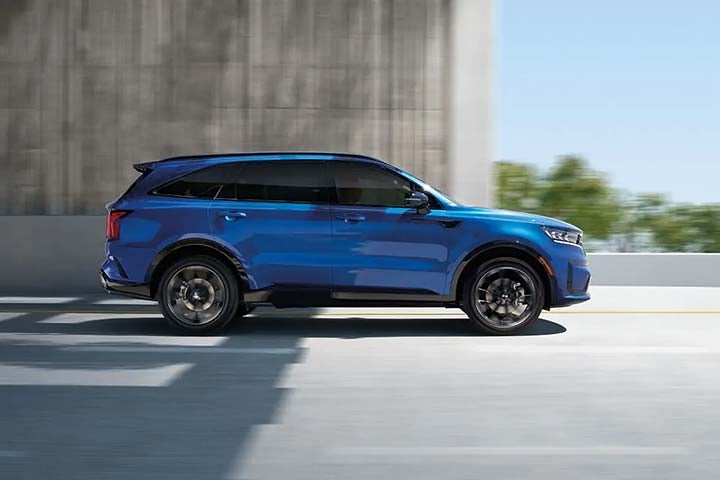 Blue 2021 Kia Sorento side view driving on blurred road – small image
