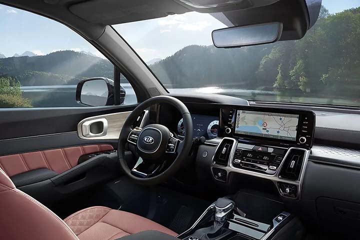Inside of 2021 Kia Sorento from perspective of front seat passenger with lake and woods visible out windshield